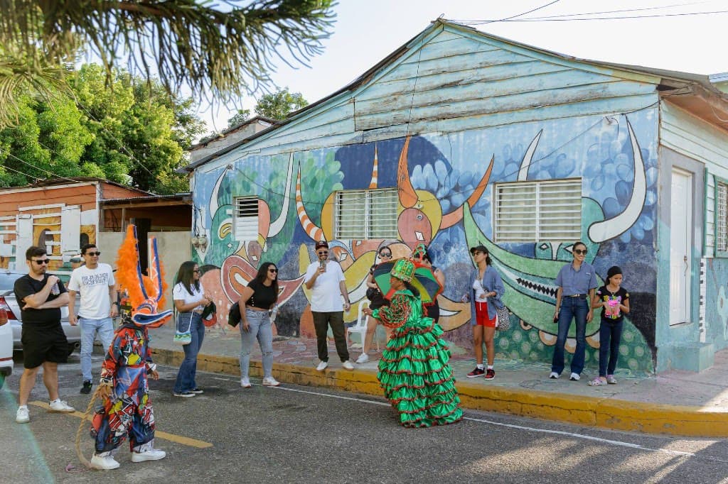 Personajes de carnaval frente a un mural